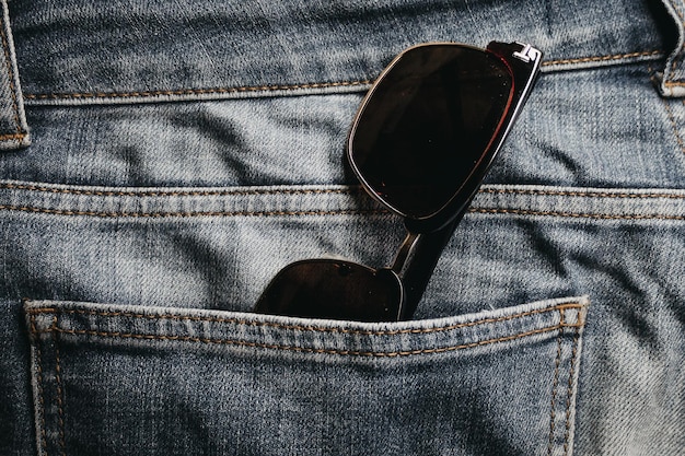 Une paire de lunettes de soleil dans la poche d'un jean