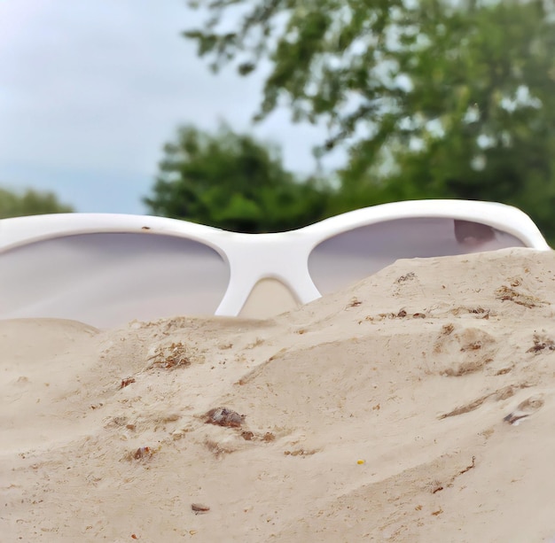 Une paire de lunettes de soleil est assise dans le sable.