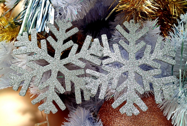 Paire d'ornements de Noël en forme de flocon de neige à paillettes d'argent sur l'arbre de Noël