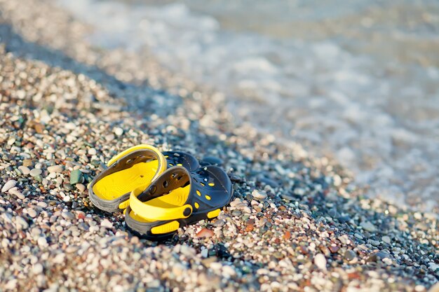 Paire de sandales pour enfants d'un nageur sur une plage en été.