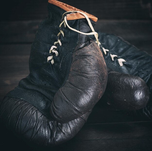 une paire de très vieux gants de boxe en cuir noir