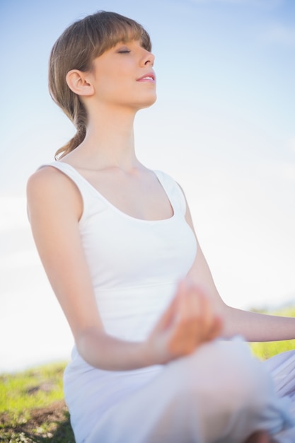 Paisible jeune femme relaxante en position de yoga