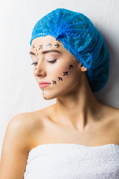 Paisible jeune patient avec des lignes pointillées sur le visage