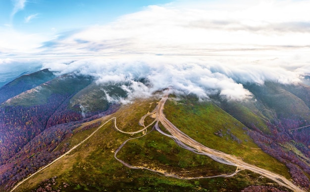 Épaisse couche de nuages blancs au-dessus de la route sur la crête de la montagne