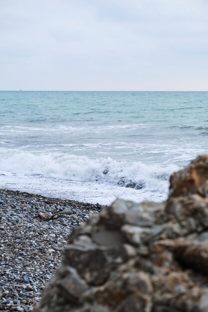 Paix et tranquillité de la nature Grande pierre de granit jaune au premier plan et mer ondulante bleue