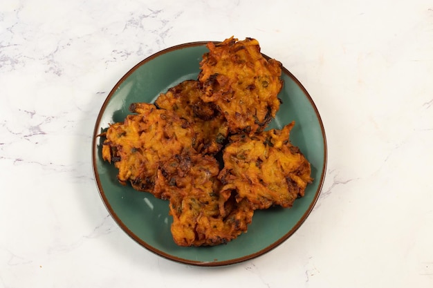 Pakora ou pakoda aux légumes épicés indiens servis dans un plat isolé sur la vue de dessus de table