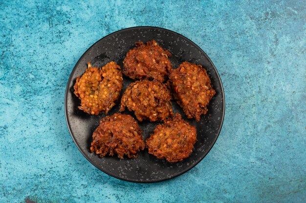 Pakora ou pakoda aux légumes épicés indiens servis dans un plat isolé sur la vue de dessus de table