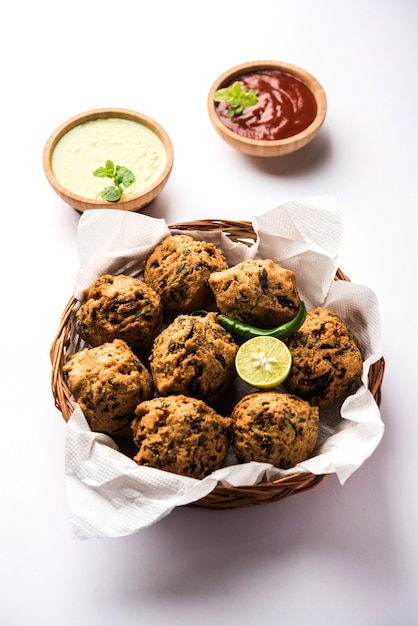 Palak OU Methi Pakora est un snack indien servi avec chutney à la menthe verte et sauce rouge, mise au point sélective