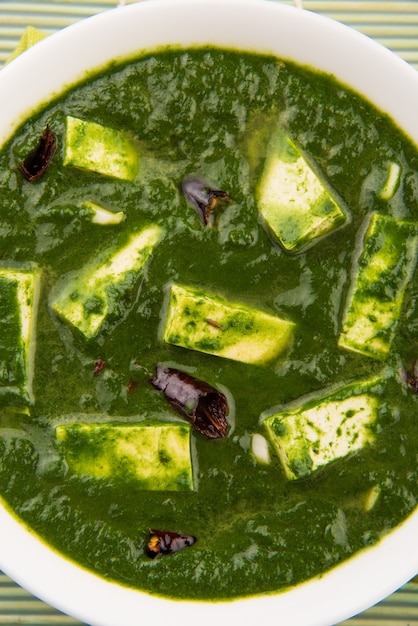 Palak paneer ou curry d'épinards et de fromage cottage est une recette de plat principal saine en Inde, servie dans un bol, isolée. mise au point sélective