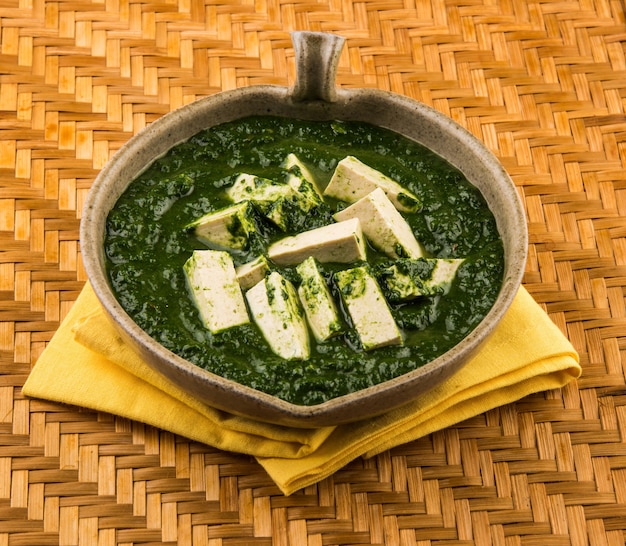 Palak paneer ou curry d'épinards et de fromage cottage est une recette de plat principal saine en Inde, servie dans un bol, isolée. mise au point sélective