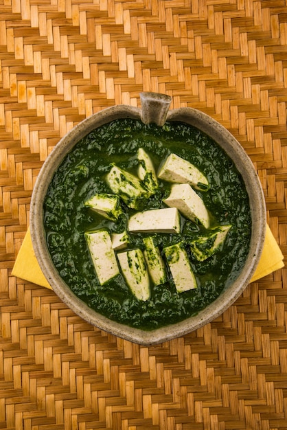 Palak paneer ou curry d'épinards et de fromage cottage est une recette de plat principal saine en Inde, servie dans un bol, isolée. mise au point sélective