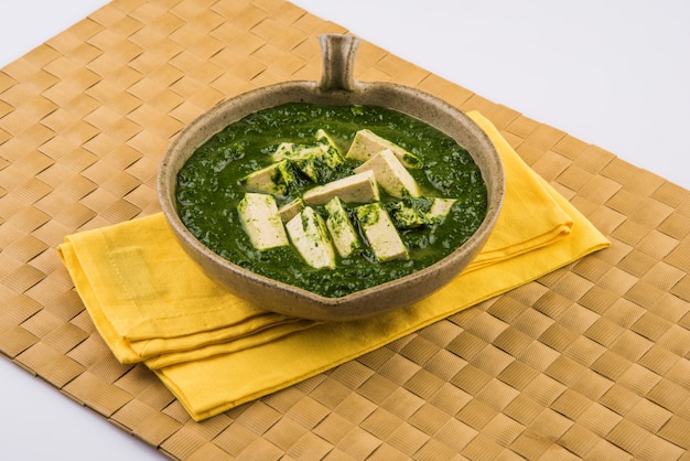 Palak paneer ou curry d'épinards et de fromage cottage est une recette de plat principal saine en Inde, servie dans un bol, isolée. mise au point sélective