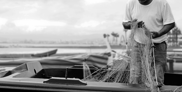 Palangre de pêche, réseaux de capture de poissons, pêcheur corrige et prépare le matériel au travail