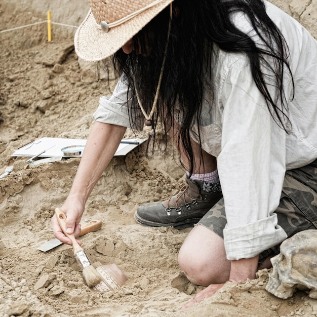 Un paléontologue travaillant sur le sable.