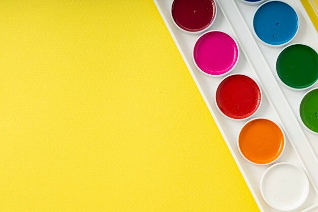 Palette d'aquarelles sur fond jaune