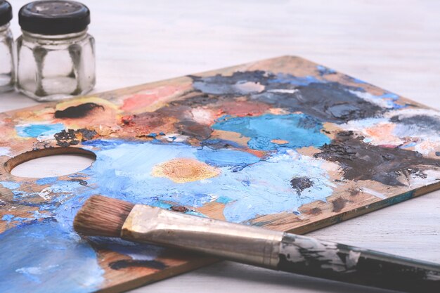 Photo palette d'artiste avec des traits de peinture à l'huile colorés et des pinceaux