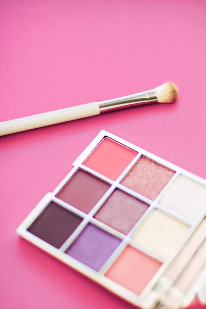 Palette de fards à paupières et pinceau de maquillage sur fond rose ombres à paupières produit cosmétique pour la promotion de la marque de beauté de luxe et la conception de blogs de mode de vacances