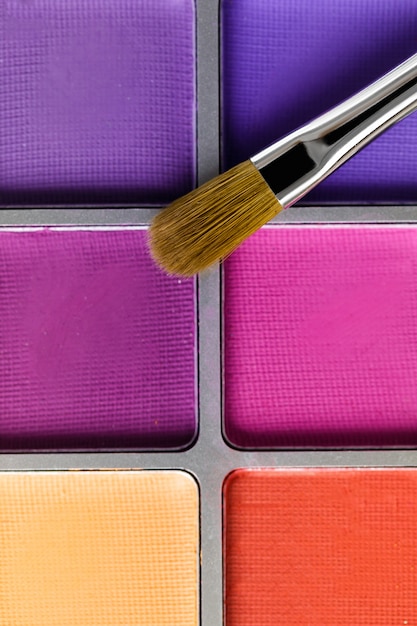 Palette de fards à paupières rose et violet et le pinceau de maquillage