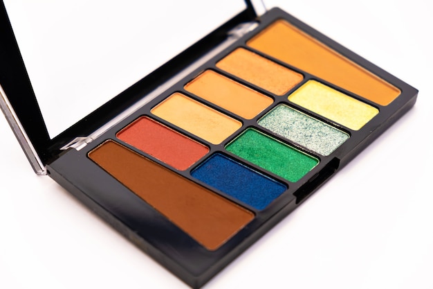 Palette de maquillage de fard à paupières coloré isolé sur une surface blanche composent des outils d'artiste