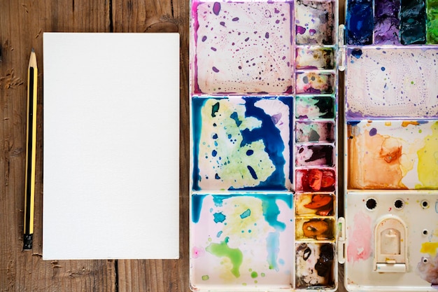 Photo la palette de peintures à l'eau sur la table de nombreuses couleurs dans la palette de peintures à l'eau