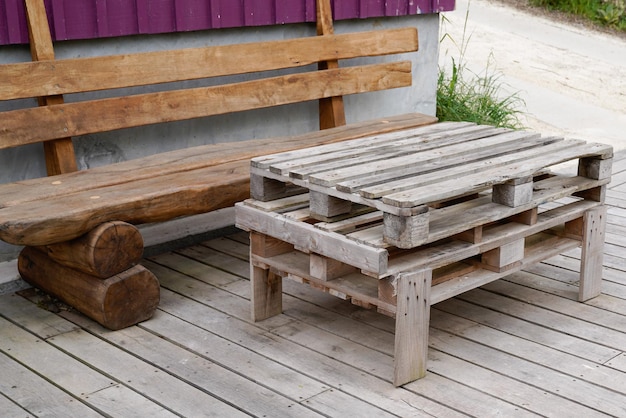 Les palettes en bois font une table de chaise longue en bois de jardin dans le jardin de la maison en plein air