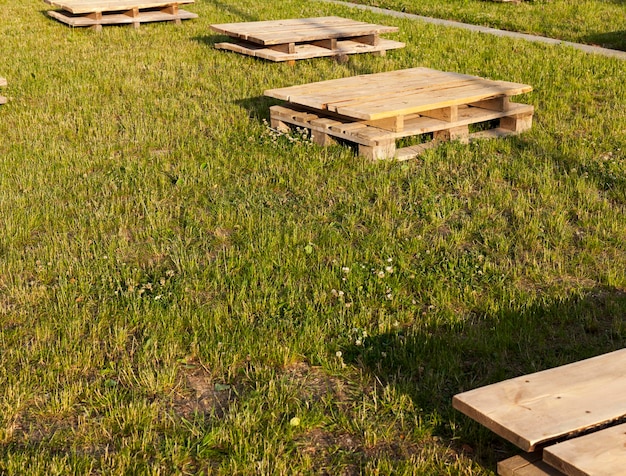 Des palettes en bois sur l'herbe, qui servent de tables ou d'endroit pour s'asseoir tout en se relaxant sur la pelouse