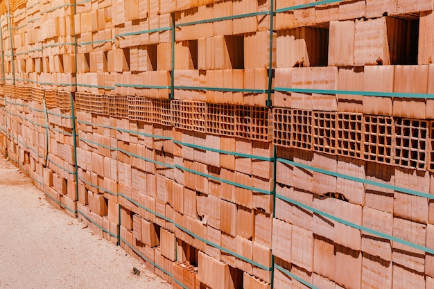 Palettes avec des racks de briques fraîchement fabriqués sur un chantier de construction ou à proximité d'une usine industrielle Stockage de matériaux de construction à l'entrepôt