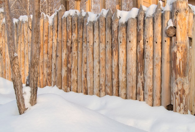 Paling, clôture en bois faite de rondins dans le village, hiver