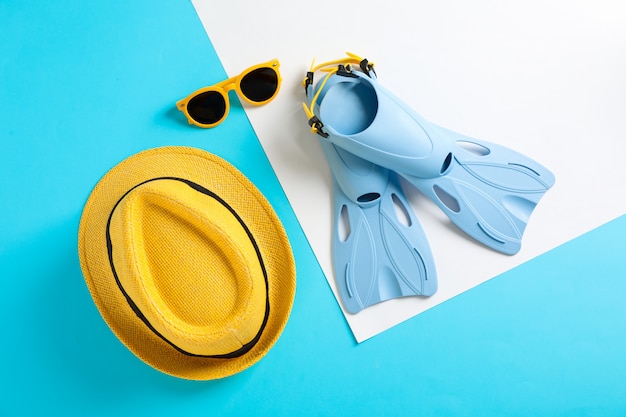 Palmes, chapeau et lunettes de soleil sur la table des couleurs