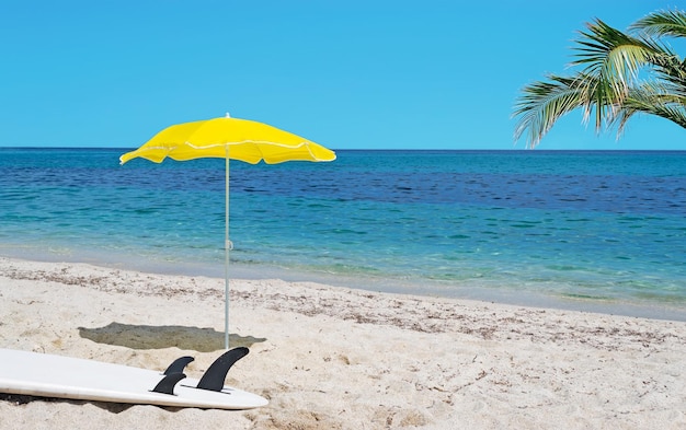 Palmier de planche de surf blanc et parasol jaune sur le sable