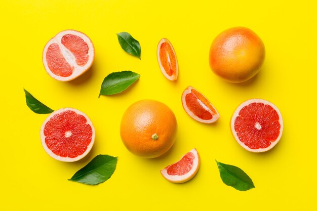 Pamplemousse de fruits frais avec des tranches de pamplemousse juteuses sur fond coloré Vue de dessus Espace de copie Concept d'été créatif La moitié des agrumes dans un plat minimal avec espace de copie