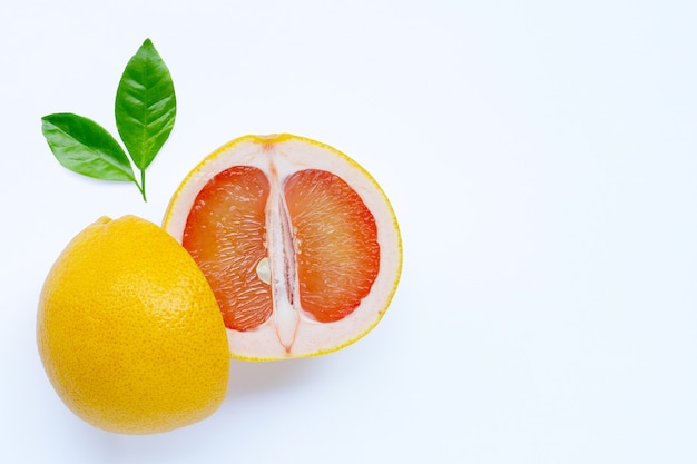 Pamplemousse juteux riche en vitamine C sur un mur blanc.