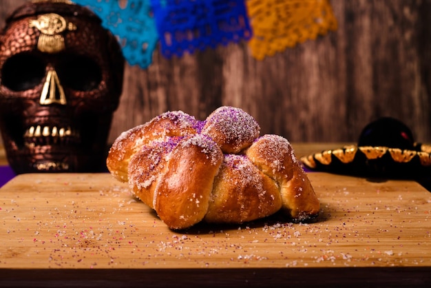 Pan de muertos et crâne peint sur table en bois. Dessert typique de la célébration du Jour des Morts