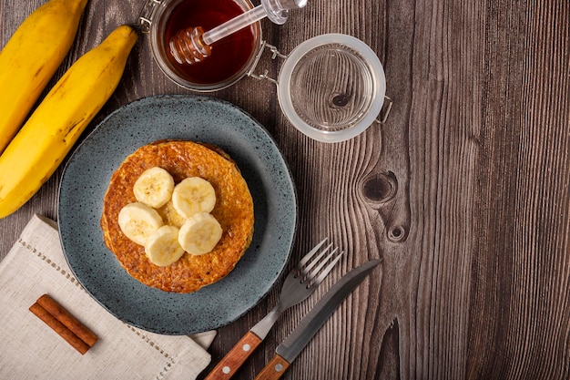 Pancakes aux bananes et à l'avoine garnis de tranches de bananes et de miel