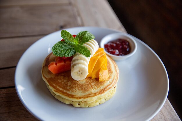 Pancakes à la banane mangue menthe et confiture de fraise pour un petit déjeuner