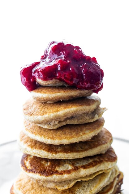 Pancakes sains à l'avoine, aux œufs et à la banane sans gluten avec de la confiture de framboises maison. Petit-déjeuner sain.