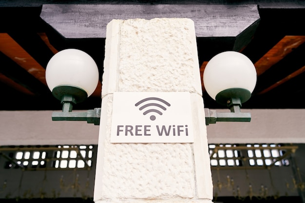 Pancarte avec une inscription sur un pilier en pierre avec inscription de lanternes wifi gratuit