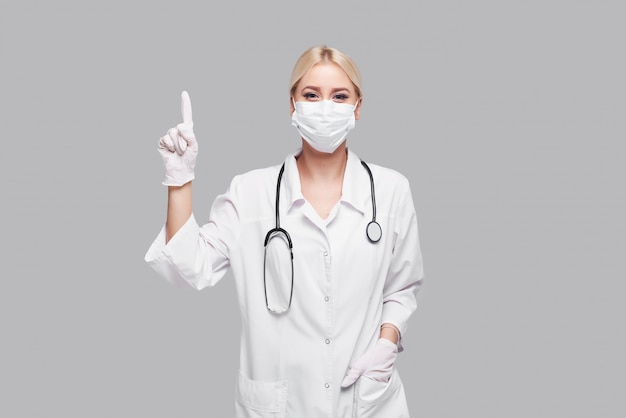 Pandémie de coronavirus. femme médecin en masque facial médical blanc avec stéthoscope. Concept de mise en quarantaine Covd-19.