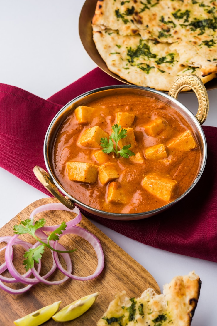 Photo paneer butter masala ou cheese cottage curry, menu populaire indien pour le déjeuner et le dîner servi à karahi avec naan ou roti sur fond de mauvaise humeur, mise au point sélective