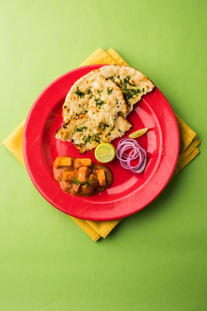 Paneer Butter Masala ou Cheese Cottage Curry, menu populaire indien pour le déjeuner et le dîner servi à Karahi avec Naan ou Roti sur fond de mauvaise humeur, mise au point sélective