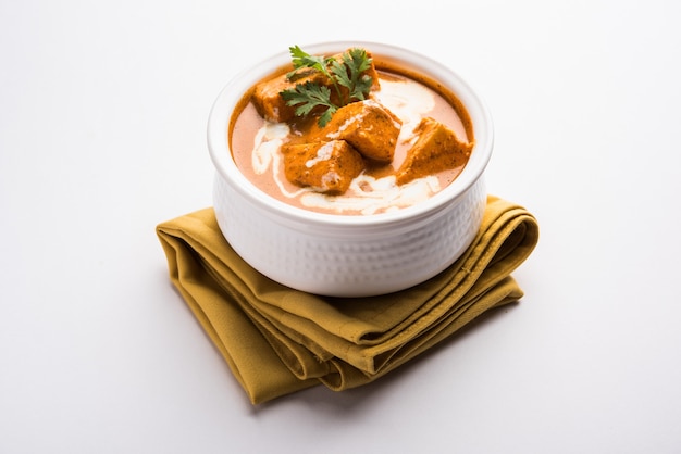 Paneer Butter Masala également connu sous le nom de Panir makhani ou makhanwala. servi dans un bol en céramique ou en terre cuite avec de la crème fraîche et de la coriandre.selective focus