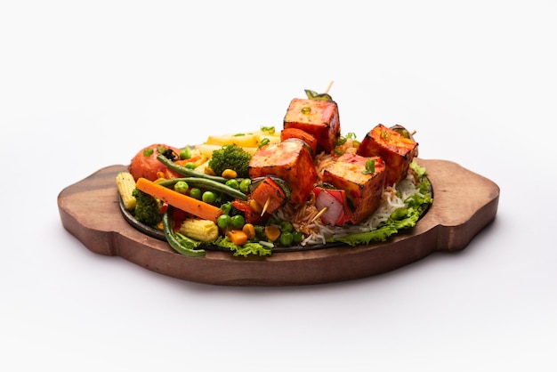 Paneer Sizzler est une version indienne avec une salade de fromage cottage servie grésillante sur un plat en pierre chaude