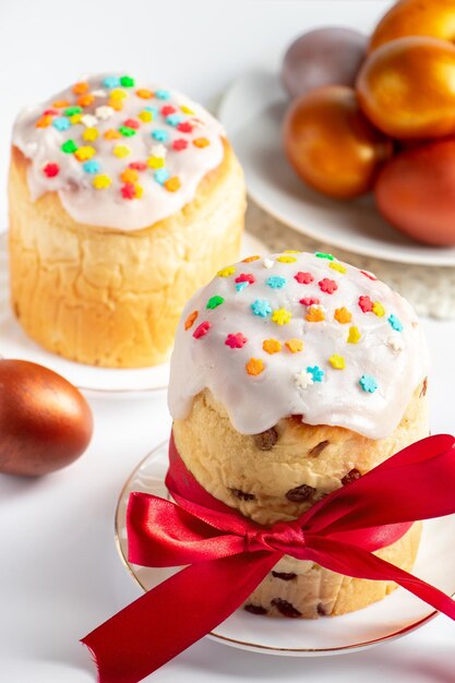 Panettone de gâteau de Pâques avec glaçage sucré et oeufs dorés sur plaque blanche Joyeuses vacances de printemps