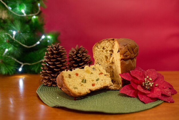 Photo panettone pain sucré italien avec des fruits secs sur un fond de noël rouge flou