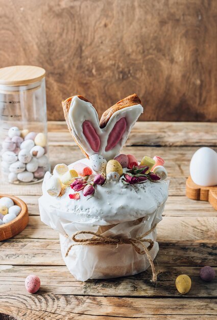 Panettone de Pâques ou pain sucré Kulich décoré d'oreilles de lapin biscuits mini oeufs en chocolat