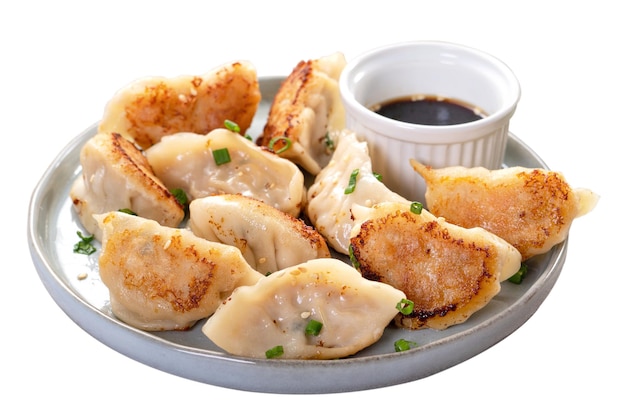 Panfried gyoza dumpling jiaozi dans une assiette isolé sur fond blanc