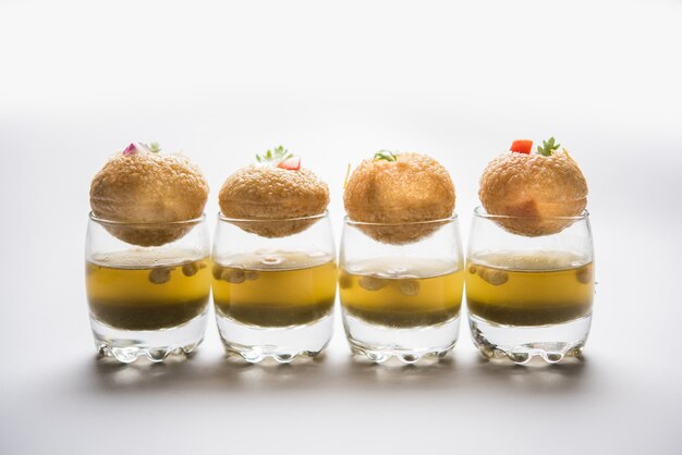 Pani Puri est un élément de chat indien au bord de la route - quatre puris farcis conservés dans de petits verres remplis d'eau à la menthe