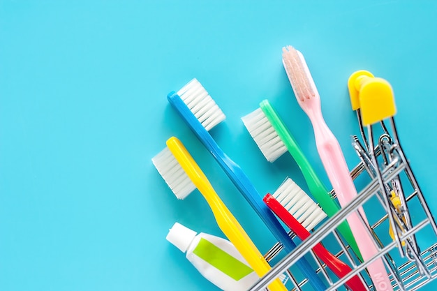 Panier d&#39;achat avec brosse à dents et dentifrice sur fond bleu