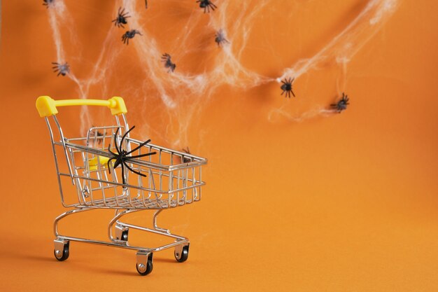 Panier avec araignée sur fond marron, halloween shopping sur concept, toiles d'araignées et araignées sur fond