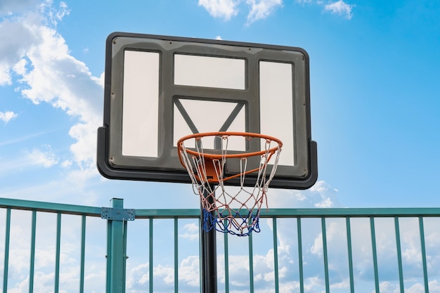 Panier de basket sur le terrain de jeu contre le ciel avec des nuages